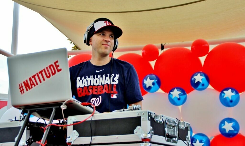 Disk jockey in front of ballons.