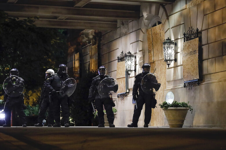 <p>Police stand under the entrance to The Hay Adams Hotel on 16th Street as demonstrators protest the death of George Floyd, Sunday, May 31, 2020, near the White House in Washington. Floyd died after being restrained by Minneapolis police officers. (AP Photo/Alex Brandon)</p>
