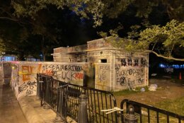 <p>A building is seen covered in graffiti near 16th Street NW in D.C. following protests. (John Domen/WTOP)</p>
