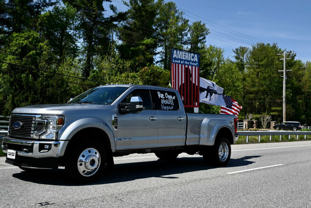 Silver pickup truck with an American flag.