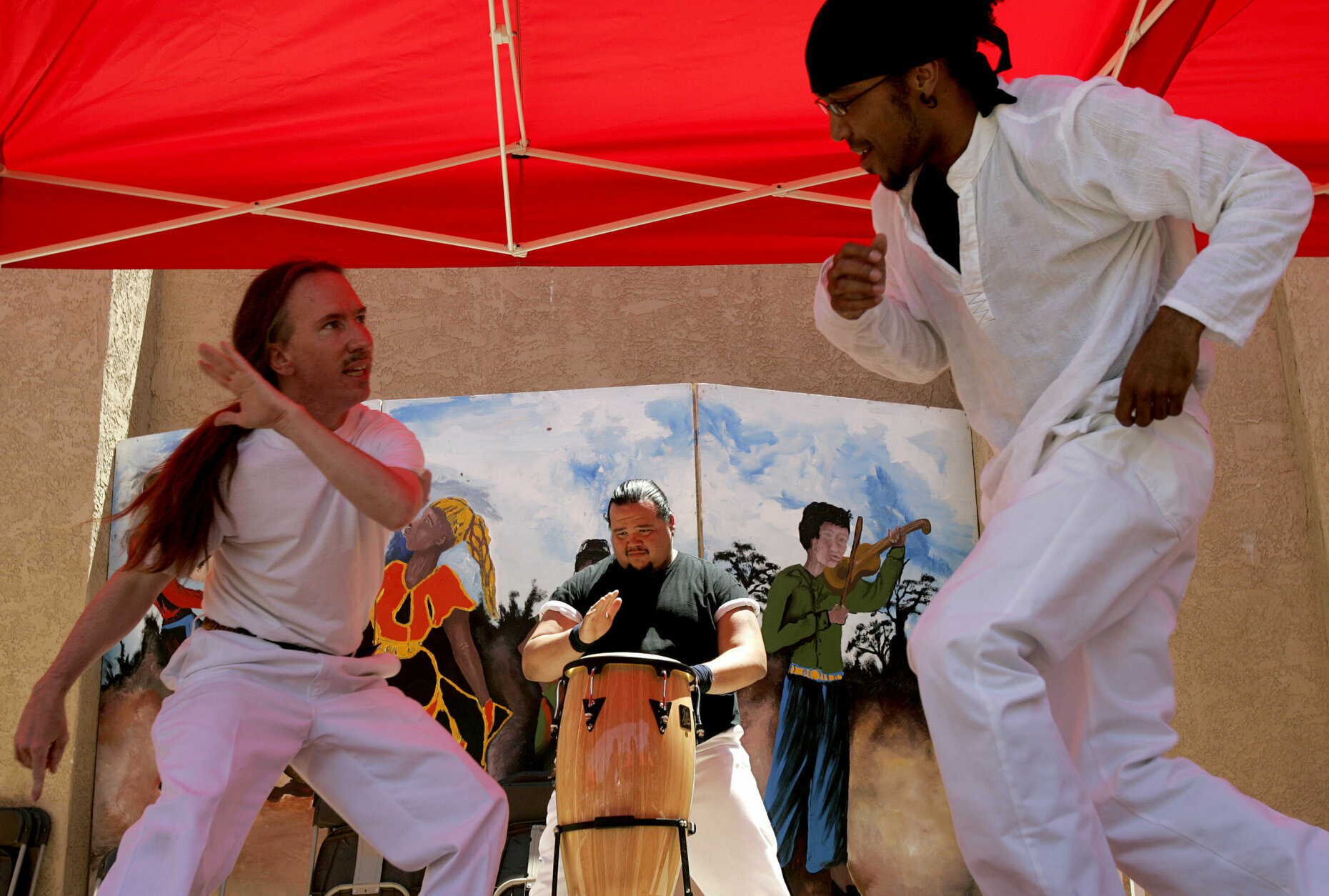 Daryl McCullick, left, Ivan Pena, center, and Tariq Sabur perform Capoeira Angola, an African Brazilian martial art, at the annual Juneteenth festival in Phoenix, Saturday, June 17, 2006. Juneteenth is the traditional celebration of the announcement in Texas in 1865 that slavery was ended. (AP Photo/Khampha Bouahanh)