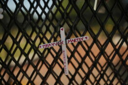 A cross with Trayvon Martin's name is tied to a fence near the White House as demonstrators protest Sunday, June 7, 2020, near the White House in Washington, over the death of George Floyd, a black man who was in police custody in Minneapolis. Floyd died after being restrained by Minneapolis police officers on Memorial Day. (AP Photo/Maya Alleruzzo)