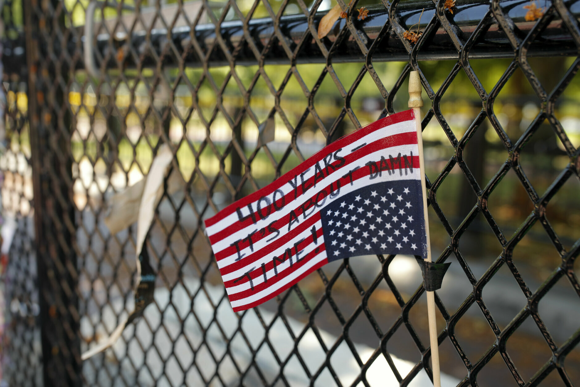 An American flag is seen upside down in a fence near the White House as demonstrators protest Sunday, June 7, 2020, in Washington, over the death of George Floyd, a black man who was in police custody in Minneapolis. Floyd died after being restrained by Minneapolis police officers on Memorial Day. (AP Photo/Maya Alleruzzo)