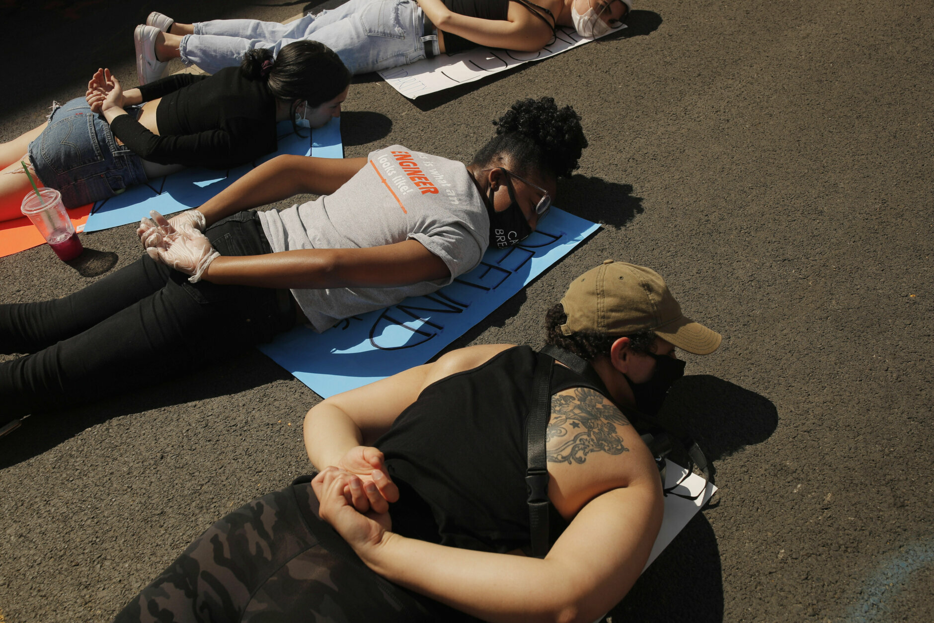 Women lie prone on the street with hundreds of others for 8 minutes and 46 seconds--the amount of time Minneapolis police restrained George Floyd--at a protest Sunday, June 7, 2020, near the White House in Washington over the death of George Floyd, who died May 25 after being restrained by police in Minneapolis. (AP Photo/Maya Alleruzzo)