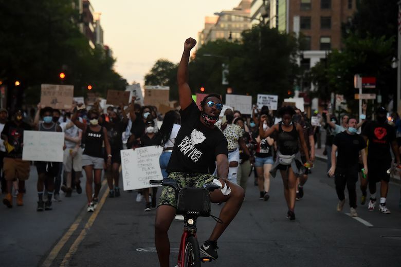 Demonstrators raise their fists as they protest against police brutality and the death of George Floyd, across from the White House on June 7, 2020 in Washington, DC. - On May 25, 2020, Floyd, a 46-year-old black man suspected of passing a counterfeit $20 bill, died in Minneapolis after Derek Chauvin, a white police officer, pressed his knee to Floyd's neck for almost nine minutes. (Photo by Olivier DOULIERY / AFP) (Photo by OLIVIER DOULIERY/AFP via Getty Images)