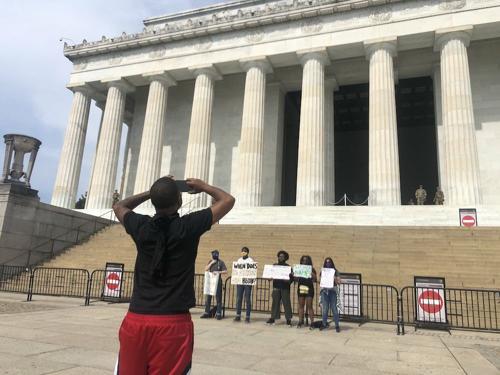 <p>A man takes pictures of demonstrators gathering ahead of protests in D.C. on Saturday</p>
