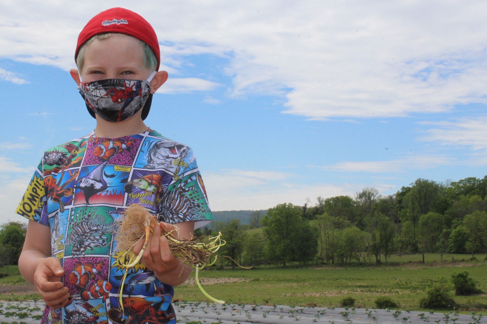 Kid in face mask on a farm.