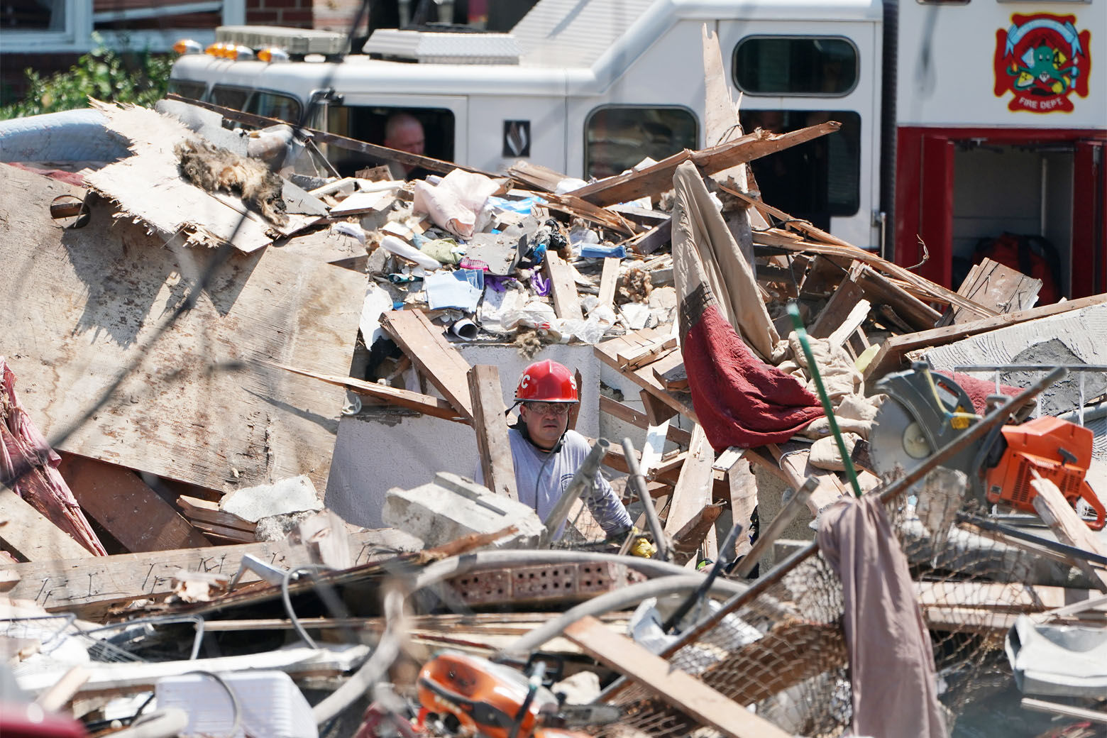 BALTIMORE, MARYLAND - AUGUST 10: A first responder digs through the rubble of three houses demolished by a gas explosion on August 10, 2020 in Baltimore, Maryland. A gas leak caused the massive explosion that leveled three homes, causing multiple injuries and at least one fatality. (Photo by J. Countess/Getty Images)