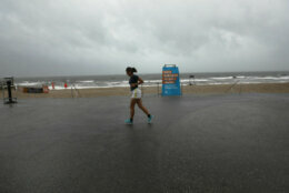 NEW YORK, NEW YORK - AUGUST 04: A woman runs along a deserted boardwalk in Rockaway, Queens as Tropical Storm Isaias churns its way up the East Coast on August 04, 2020 in New York City.The storm, which regained hurricane strength Monday night, is expected to bring heavy rainfall, lightning, strong winds and flooding to the New York City area on Tuesday afternoon. (Photo by Spencer Platt/Getty Images)