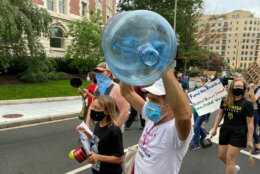 Protester holding a large empty water container