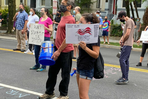 Dozens protest outside postmaster general’s DC condo