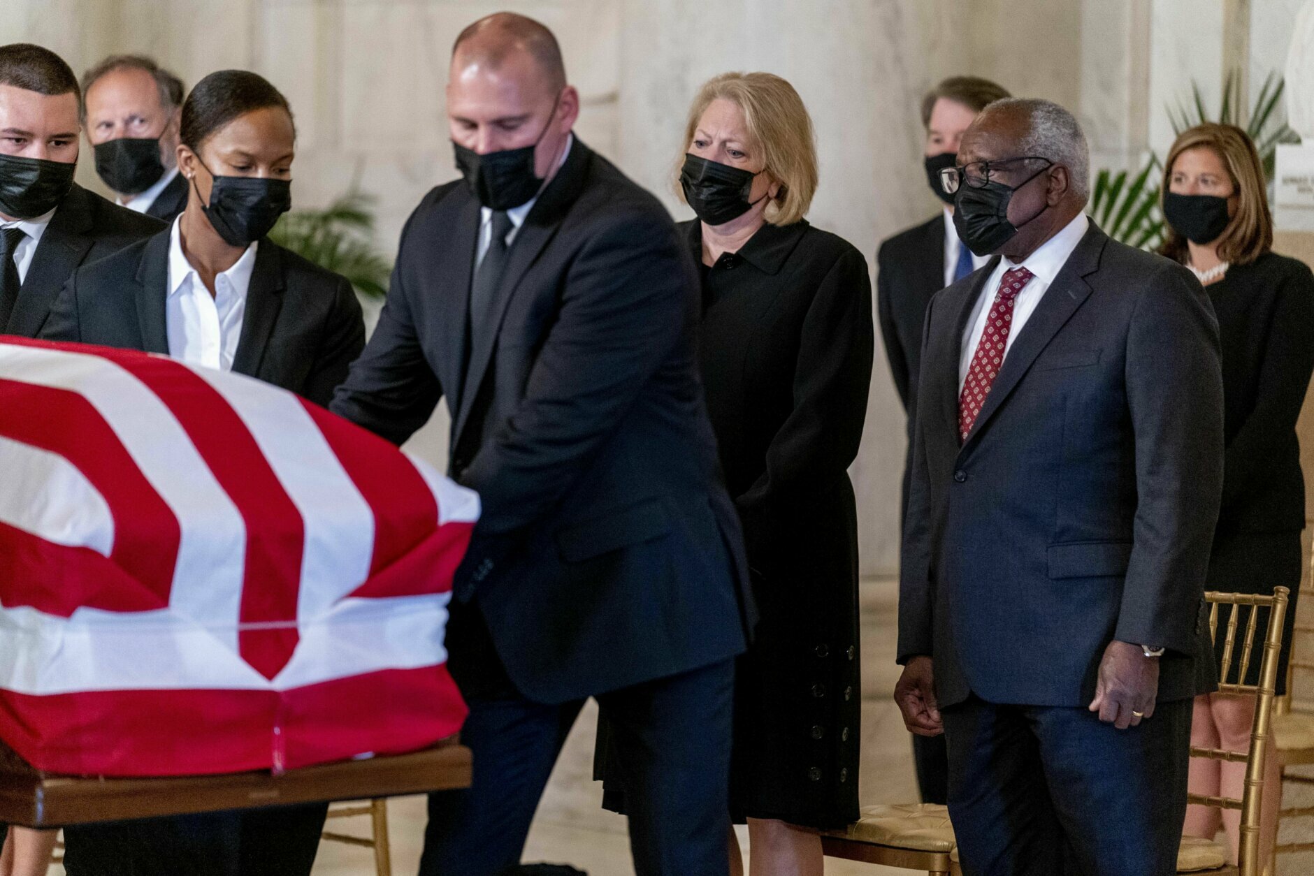 Justice Clarence Thomas, right, and his wife Virginia Thomas, center, watch as the flag-draped casket of Justice Ruth Bader Ginsburg arrives at the Supreme Court in Washington, Wednesday, Sept. 23, 2020. Ginsburg, 87, died of cancer on Sept. 18. (AP Photo/Andrew Harnik, Pool)