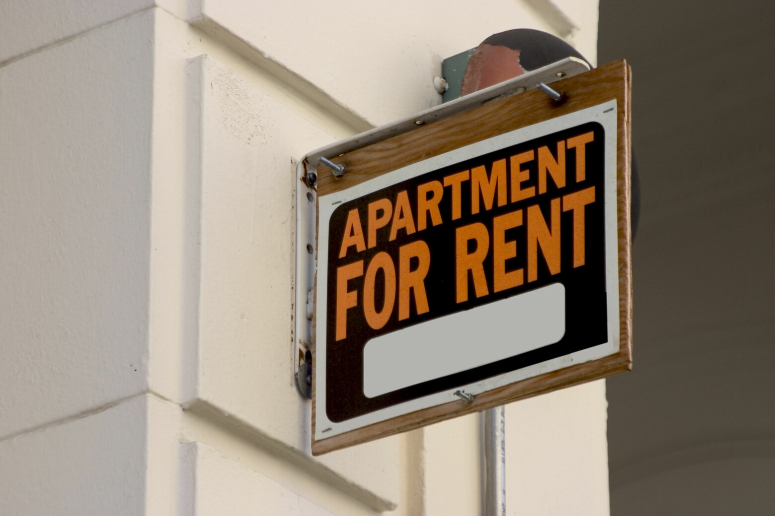 A for rent sign on display on the side of an apartment building.