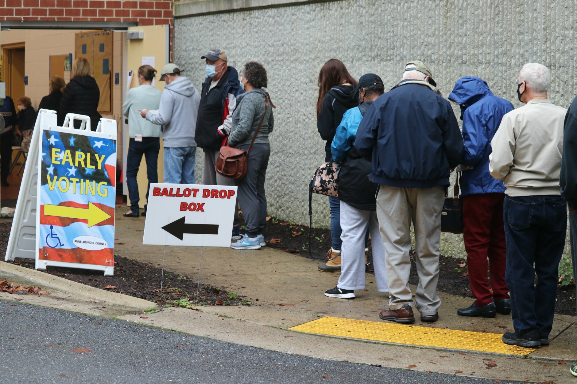Voters wait in line to enter the Pip Moyer Recreation Center, Monday, Oct. 26, 2020 in Annapolis, Md., on the first day of in-person early voting in the state. (AP Photo/Brian Witte)