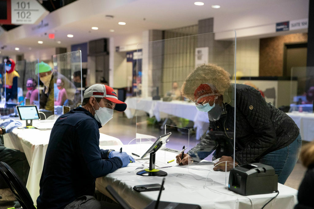 WASHINGTON, DC - OCTOBER 27: A woman checks in to cast her ballot at an early voting center at the Capitol One Arena on October 27, 2020 in Washington, DC. Early voting for the 2020 general election starts today in Washington, DC at 32 polling locations across the city and runs through November 2. (Photo by Sarah Silbiger/Getty Images)