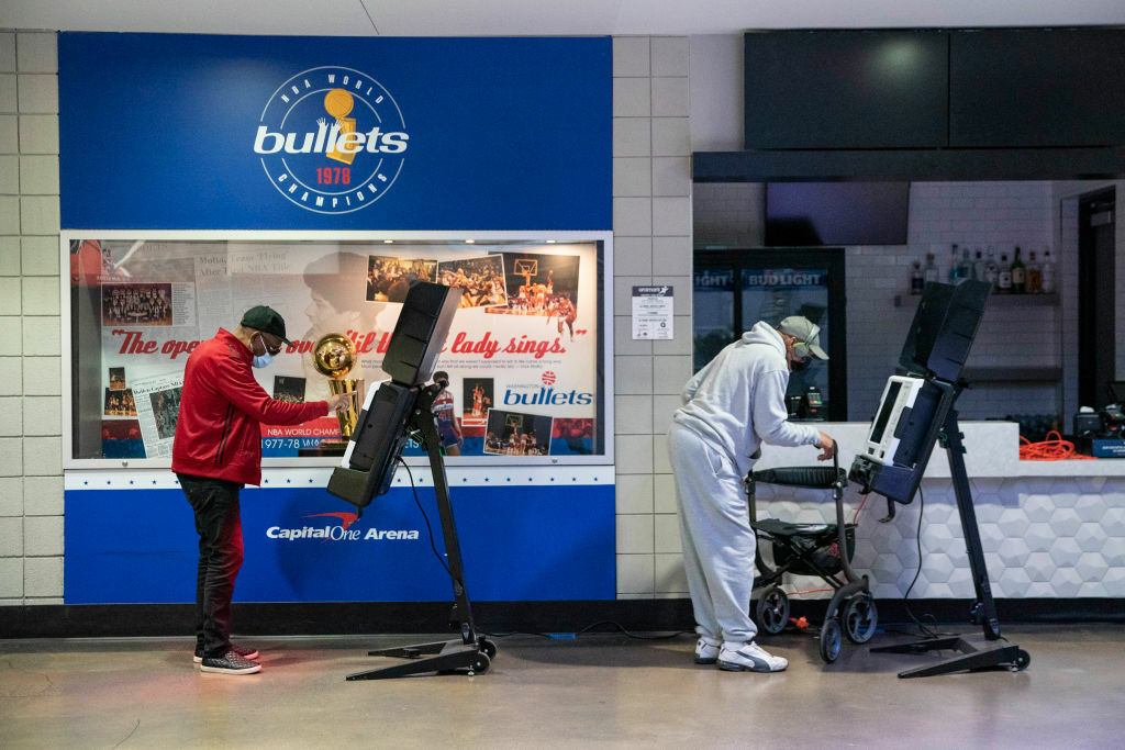 WASHINGTON, DC - OCTOBER 27: People cast their ballots at an early voting center at the Capitol One Arena on October 27, 2020 in Washington, DC. Early voting for the 2020 general election starts today in Washington, DC at 32 polling locations across the city and runs through November 2. (Photo by Sarah Silbiger/Getty Images)