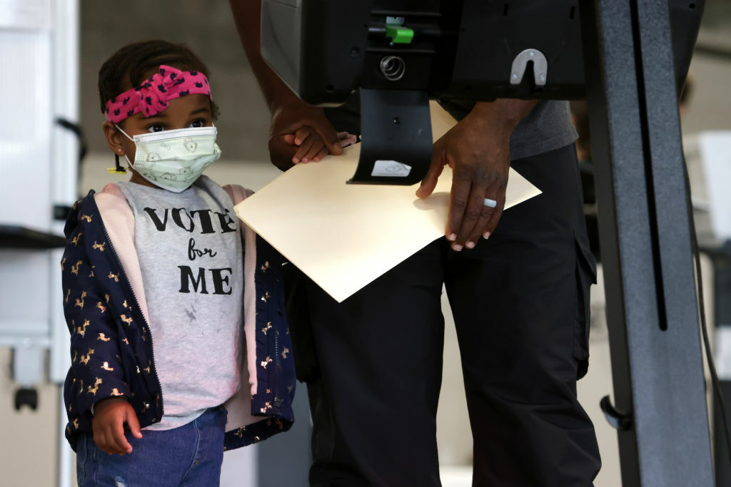 WASHINGTON, DC - OCTOBER 27:  Two-year-old Aissatou Barry accompanies her father to vote at an early voting center at Union Market October 27, 2020 in Washington, DC. Early voting for the 2020 general election starts today in Washington, DC at 32 polling locations across the city and runs through November 2. (Photo by Alex Wong/Getty Images)