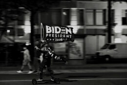 A man skateboards down K Street, NW, with a Joe Biden flag in Washington, DC on Saturday, November 7.