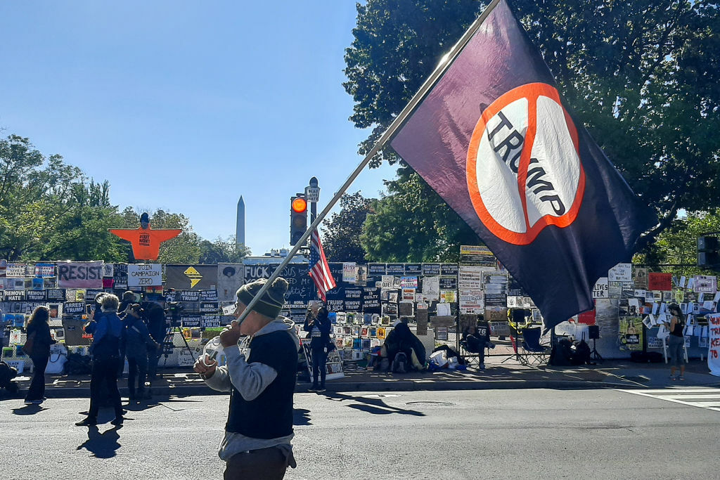 WASHINGTON, D.C., USA - NOVEMBER 3, 2020: A man holds an anti President Donald Trump flag on Election Day. On November 3, 2020, the United States elects its president and vice president, 35 Senators, all 435 members of the House of Representatives, 13 governors of 11 states and two US territories, as well as state and local government officials. Incumbent Republican President Donald Trump and Democratic Party nominee Joe Biden are running for president. Vladimir Kostyrev/TASS (Photo by Vladimir KostyrevTASS via Getty Images)