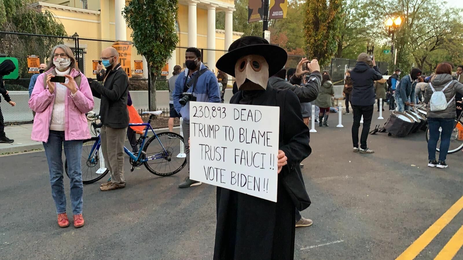 <p>A protester wears a costume and holds a sign denouncing President Donald Trump.</p>
