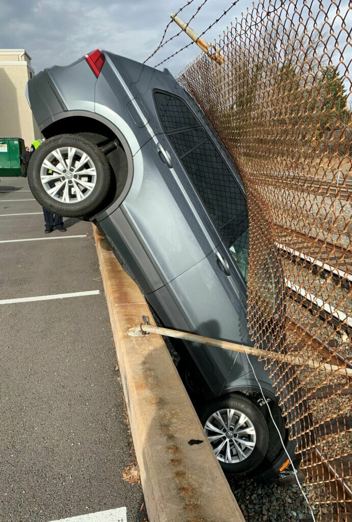 Woman trying to park car crashes through fence, disrupts Red Line