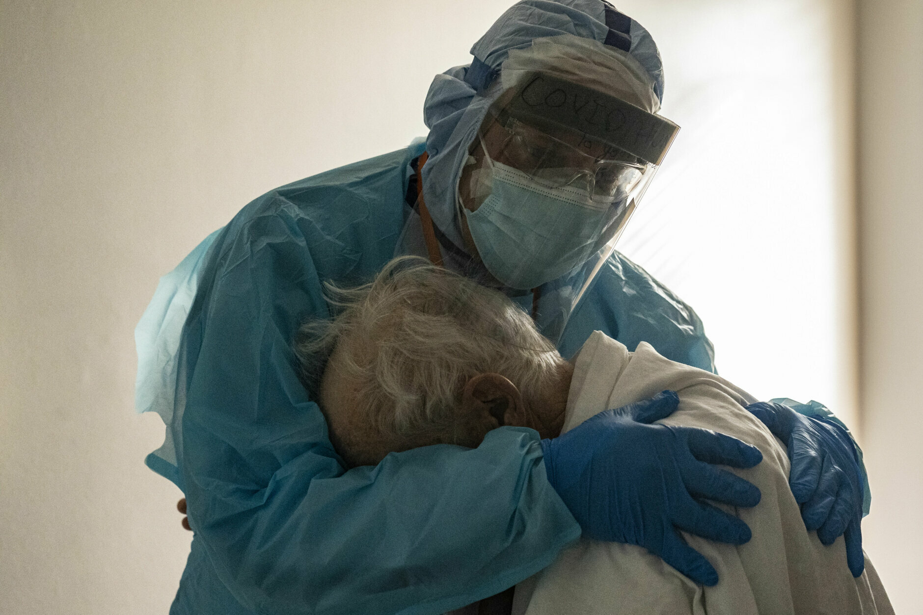 Healthcare worker hugging patient.