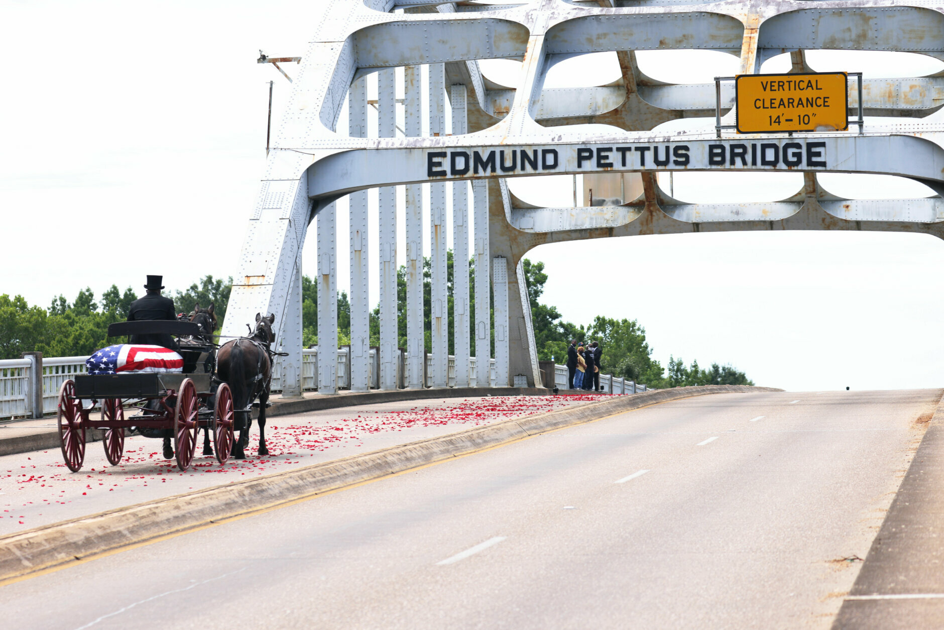 A horse drawn carriage crossing a bridge.