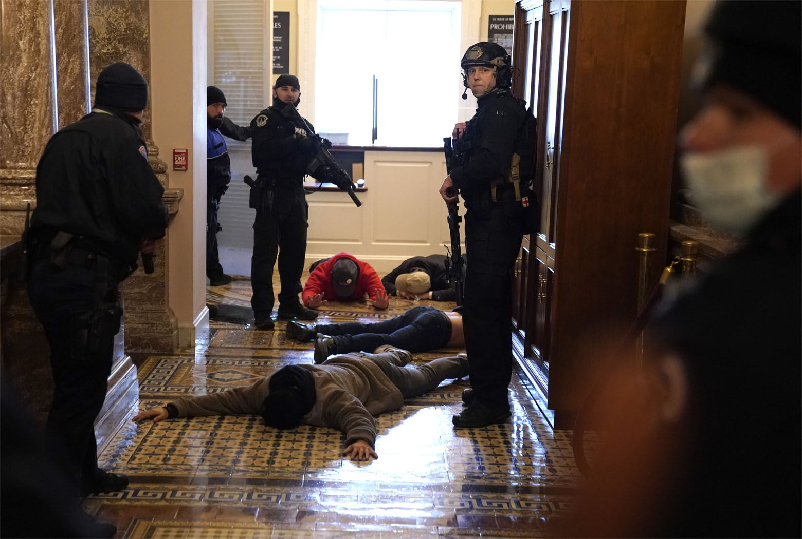 WASHINGTON, DC - JANUARY 06: U.S. Capitol Police stand detain protesters outside of the House Chamber during a joint session of Congress on January 06, 2021 in Washington, DC. Congress held a joint session today to ratify President-elect Joe Biden's 306-232 Electoral College win over President Donald Trump. A group of Republican senators said they would reject the Electoral College votes of several states unless Congress appointed a commission to audit the election results. (Photo by Drew Angerer/Getty Images)