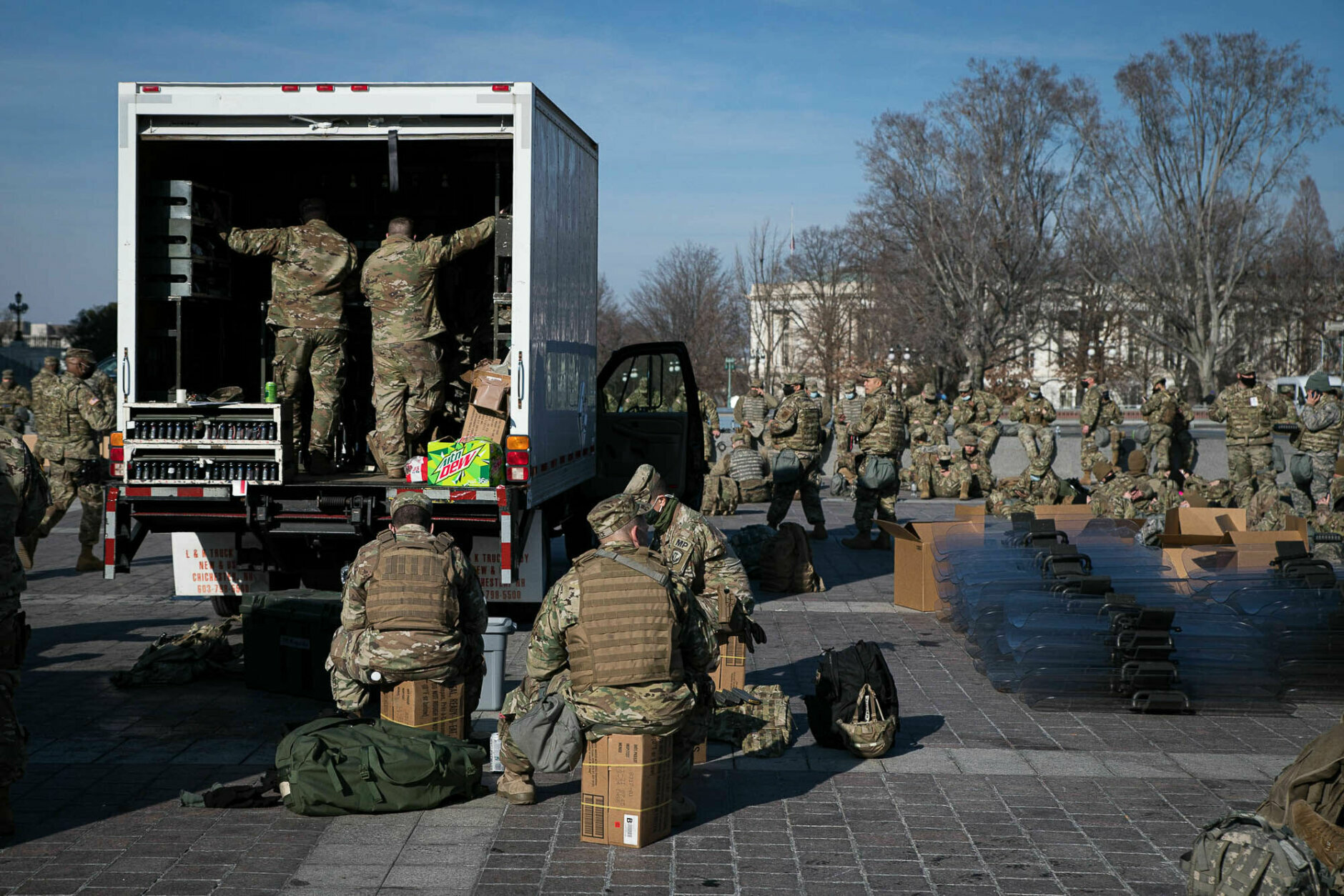 National Guard take a rest beside a stockpile of riot shields outside the U.S. Capitol building on Jan. 13, 2021. More than 20,000 armed guardsmen are expected to provide security in the nation's capital amid threats against the inauguration of President-elect Joe Biden. (WTOP/Alejandro Alvarez)