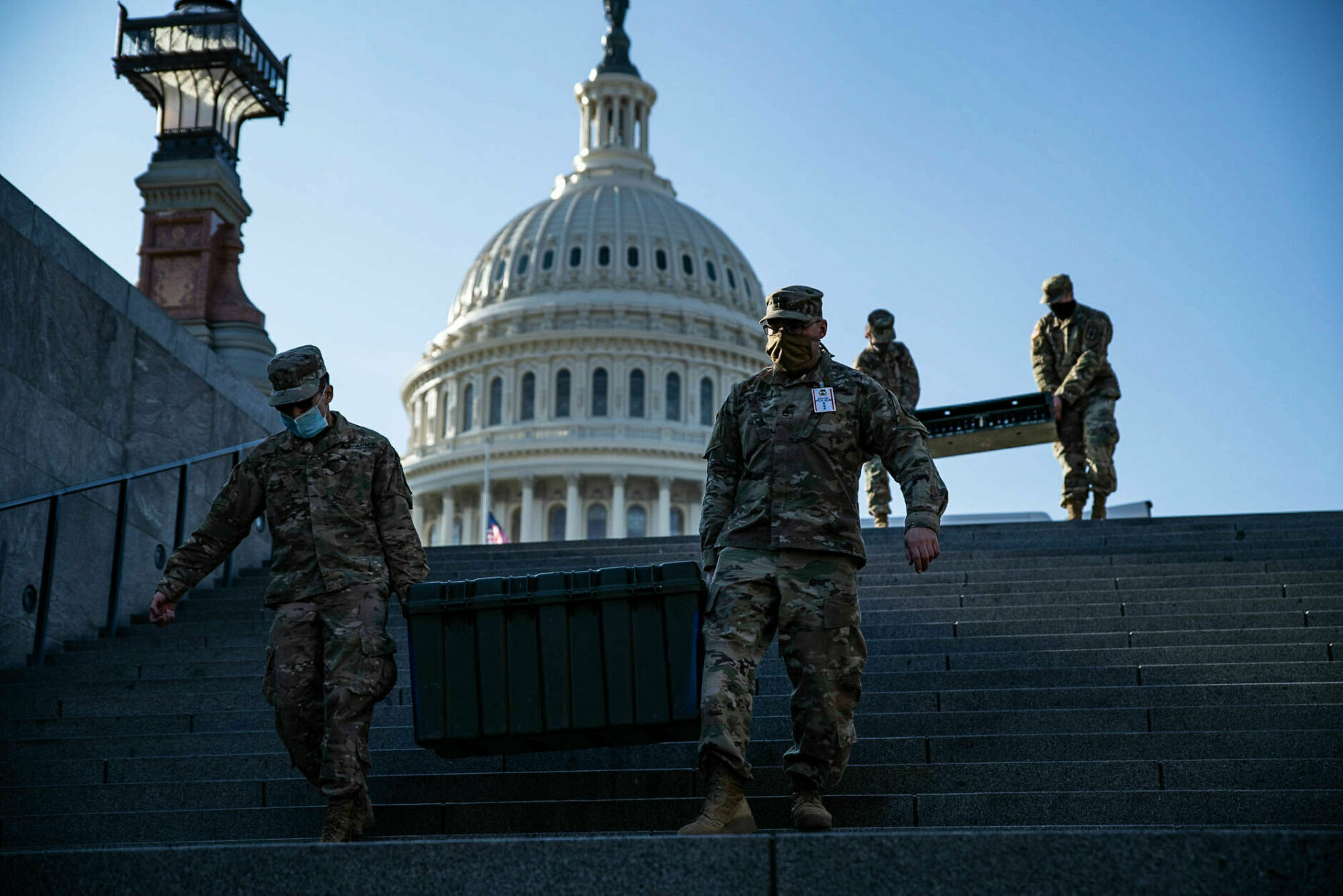 Members of the National Guard transport boxes of weapons near the U.S. Capitol visitor center on Jan. 13, 2021. More than 20,000 armed guardsmen are expected to provide security in the nation's capital amid threats against the inauguration of President-elect Joe Biden. (WTOP/Alejandro Alvarez)