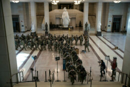 National Guard march out of the U.S. Capitol visitor center, under the gaze of the Statue of Freedom, on Jan. 13, 2021. More than 20,000 armed guardsmen are expected to provide security in the nation's capital amid threats against the inauguration of President-elect Joe Biden. (WTOP/Alejandro Alvarez)