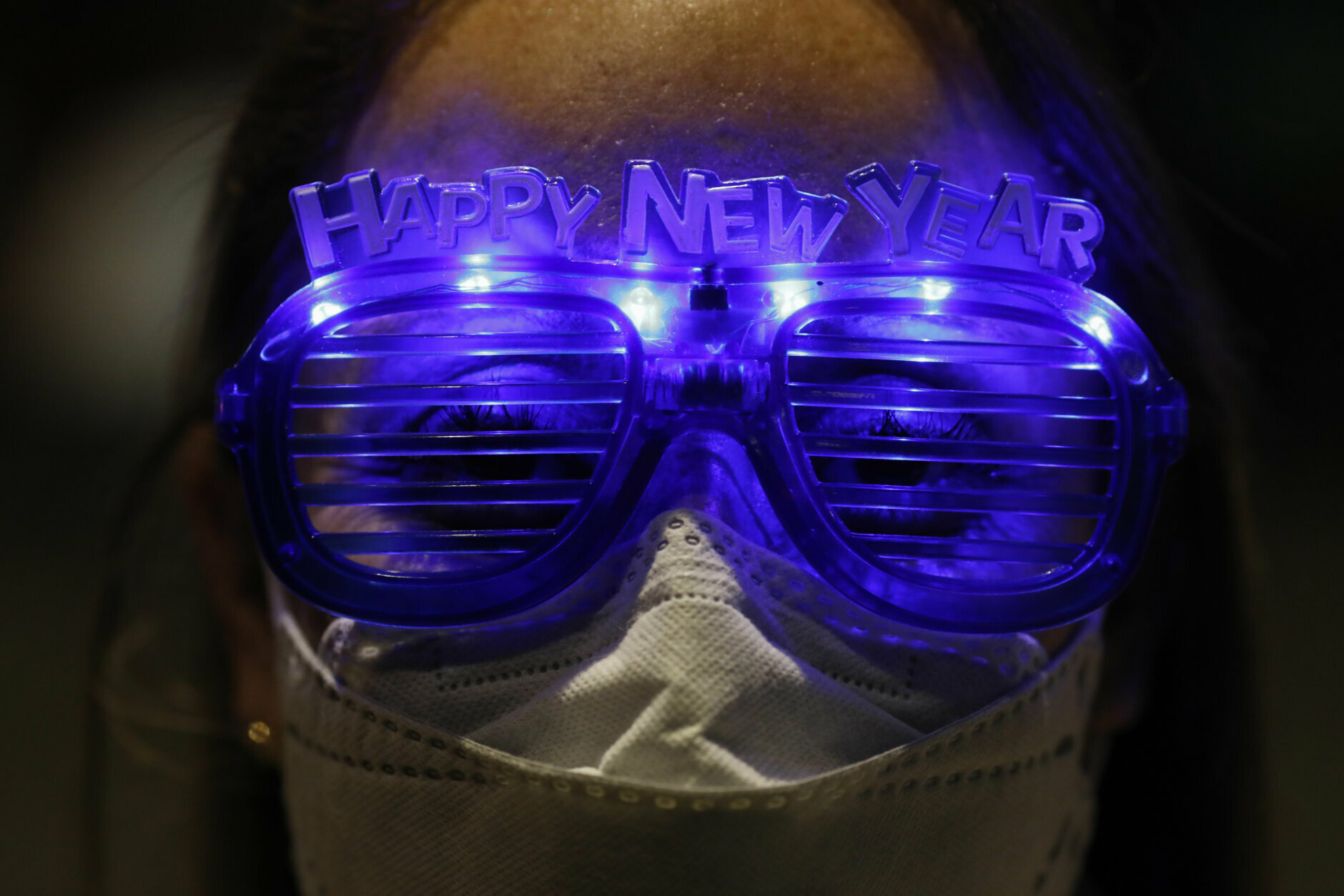 Alejandra Paiz, a tourist from Guatemala who is visiting Mexico for the holidays with a friend and their respective sons, wears festive glasses as the group marks New Year's Eve at the Angel of Independence monument in Mexico City, just after midnight on Friday, Jan. 1, 2021. Although Mexico City cancelled its annual New Year's celebration to curb the spread of the COVID-19 pandemic, dozens of people came out in small groups to mark midnight with selfies and video calls from the iconic city landmark.(AP Photo/Rebecca Blackwell)