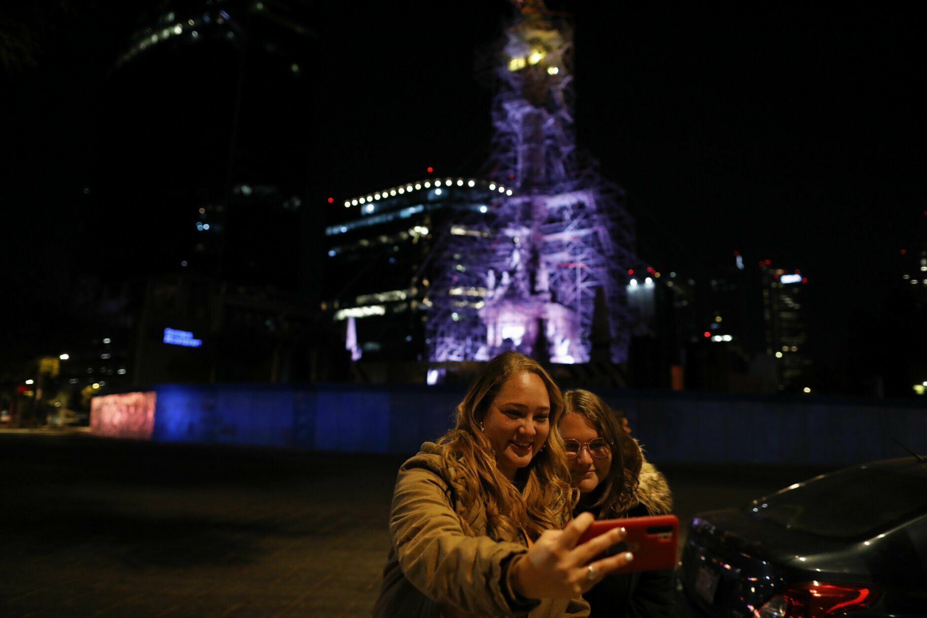 Women take a selfie in front of the Angel of Independence monument, covered in scaffolding, just before midnight on New Year's Eve, Thursday, Dec. 31, 2020. Although Mexico City cancelled its annual New Year's celebration to curb the spread of the COVID-19 pandemic, dozens of people came out in small groups to mark midnight with photos and video calls from the iconic city landmark. (AP Photo/Rebecca Blackwell)