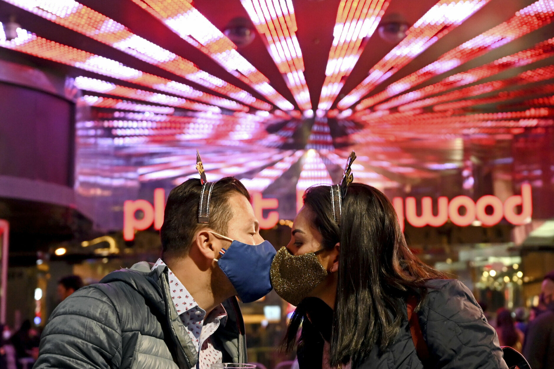 A couple wearing face masks kisses as they celebrate New Year's Eve along the Las Vegas Strip Thursday, Dec 31, 2020, in Las Vegas. (AP Photo/David Becker)