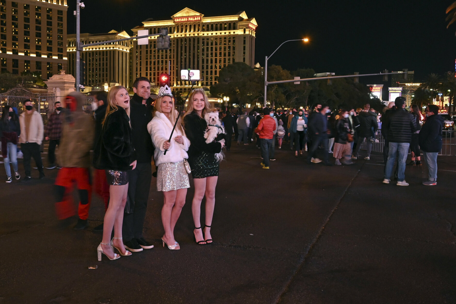 The Gallup family, from left, Sadie, Greg, Holly and Makenzie take a selfie along the Las Vegas Strip as they celebrate New Year's Eve Thursday, Dec. 31, 2020, in Las Vegas. (AP Photo/David Becker)