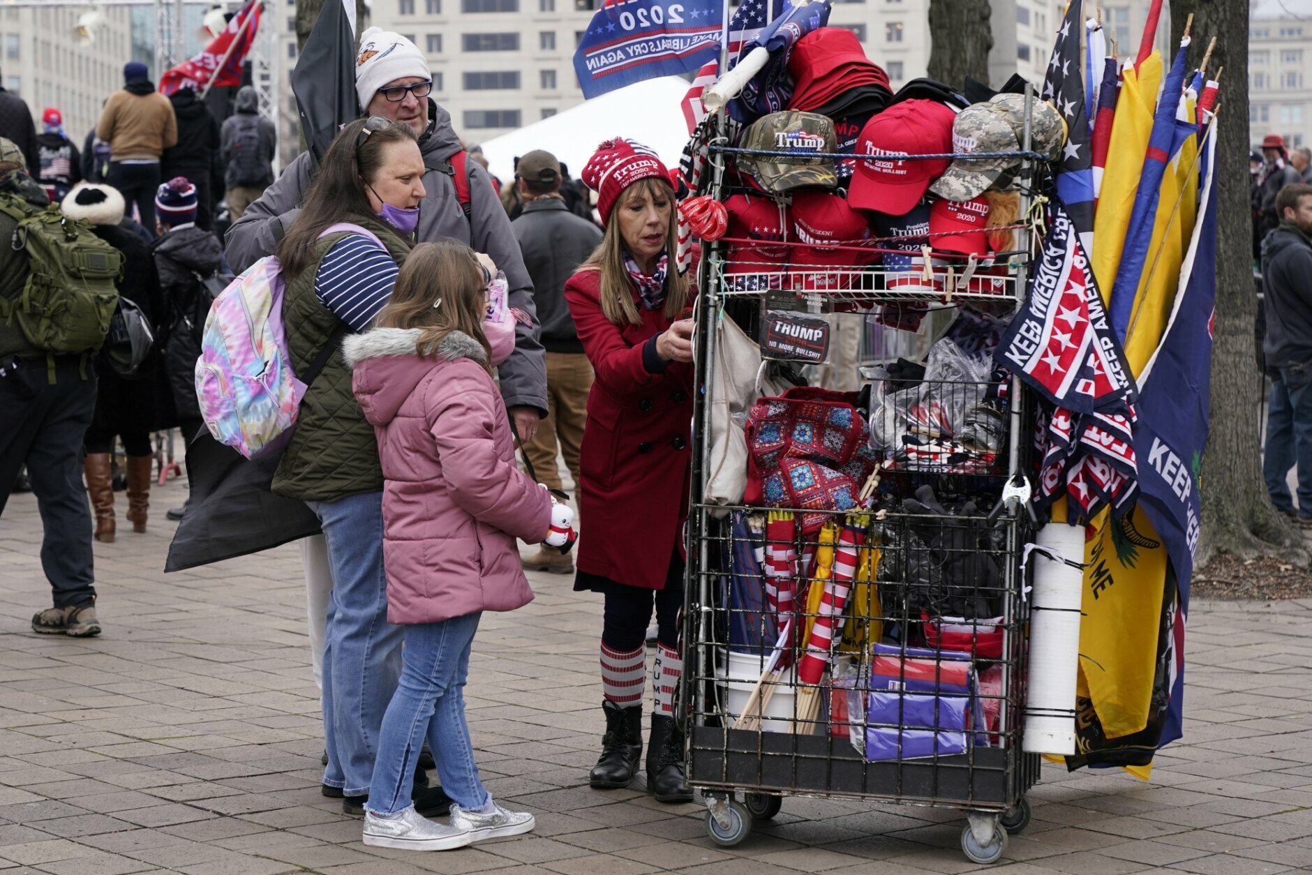 People attending a rally at Freedom Plaza Tuesday, Jan. 5, 2021, in Washington, in support of President Donald Trump, look at merchandise offered for sale by a vendor. (AP Photo/Jacquelyn Martin)
