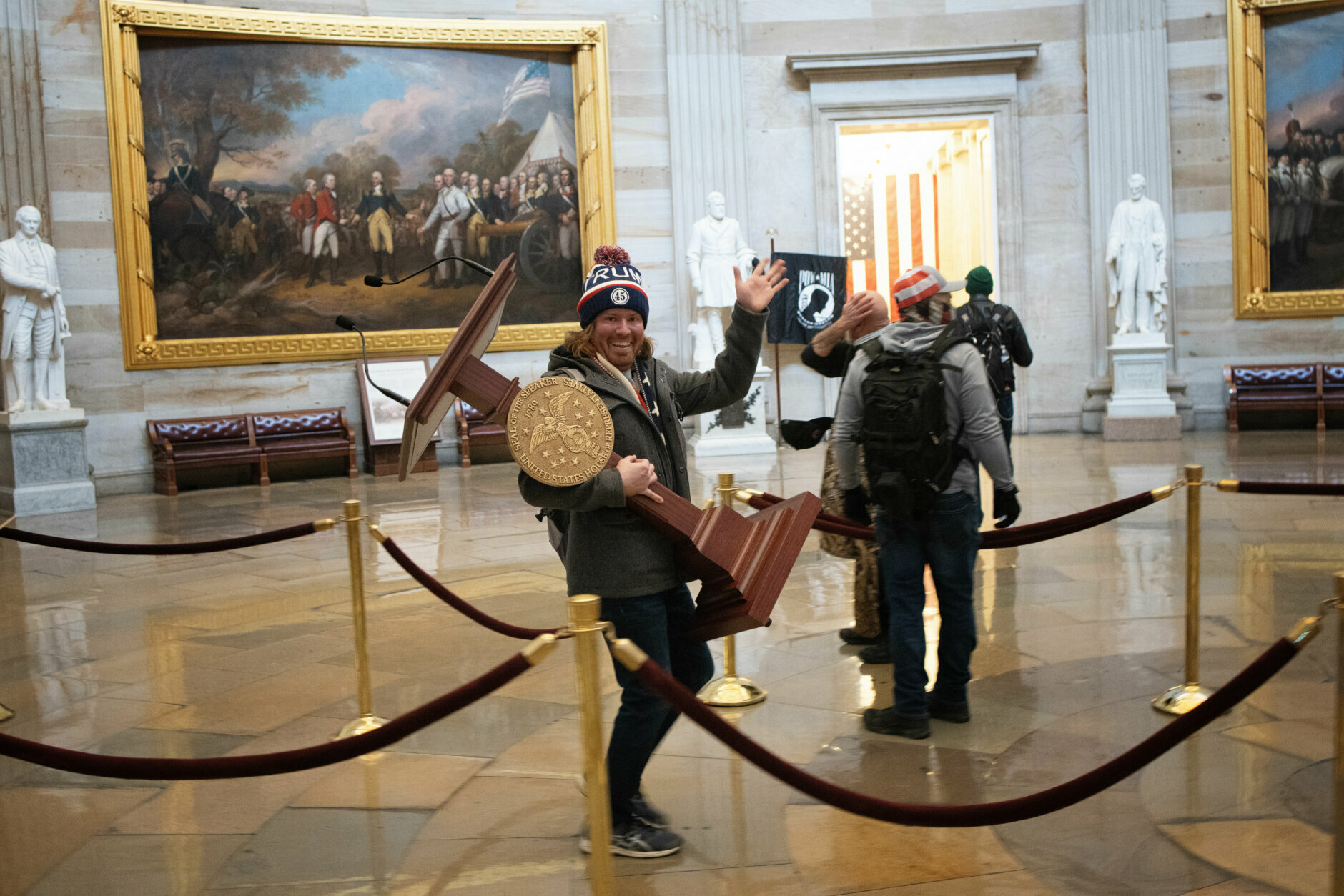 WASHINGTON, DC - JANUARY 06:  A pro-Trump protester carries the lectern of U.S. Speaker of the House Nancy Pelosi through the Roturnda of the U.S. Capitol Building after a pro-Trump mob stormed the building on January 06, 2021 in Washington, DC. Congress held a joint session today to ratify President-elect Joe Biden's 306-232 Electoral College win over President Donald Trump. A group of Republican senators said they would reject the Electoral College votes of several states unless Congress appointed a commission to audit the election results. (Photo by Win McNamee/Getty Images)