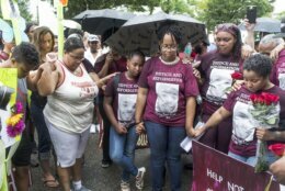 FILE - Family members, including Princess Blanding, center right, sister of Marcus-David Peters, her daughter, Tionna Blanding, 10, center left, cousin Rachel Melvin, right, and others pray after a march for Peters in front of Richmond Police Headquarters in Richmond, Va, on Saturday, June 2, 2018.  An unusually broad field is vying to be the next governor of Virginia as the marquee political contest of 2021 gets into full swing. (Daniel Sangjib Min/Richmond Times-Dispatch via AP)