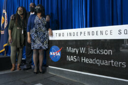 The grandchildren of Mary W. Jackson, from left, KaShawnta Lee, Bryan Jackson, and Wanda Jackson, all of Hampton, Va., stand for a photograph by the sign honoring their grandmother at a ceremony officially naming the NASA Headquarters building in honor of Mary W. Jackson, who was the first Black female engineer at NASA, Friday, Feb. 26, 2021, in Washington. "I can't even explain how I feel today," said Bryan Jackson. (AP Photo/Jacquelyn Martin)