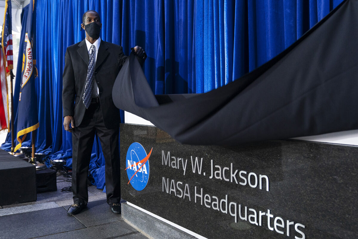 Bryan Jackson, of Hampton, Va., lifts a cloth off of a sign during an unveiling ceremony honoring his grandmother, Mary W. Jackson, at a ceremony officially naming the NASA Headquarters building in honor of Jackson, who was the first Black female engineer at NASA, Friday, Feb. 26, 2021, in Washington. "I can't even explain how I feel today," said Bryan Jackson. (AP Photo/Jacquelyn Martin)