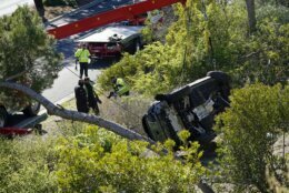 A vehicle rests on its side after a rollover accident involving golfer Tiger Woods Tuesday, Feb. 23, 2021, in the Rancho Palos Verdes suburb of Los Angeles. Woods suffered leg injuries in the one-car accident and was undergoing surgery, authorities and his manager said. (AP Photo/Marcio Jose Sanchez)