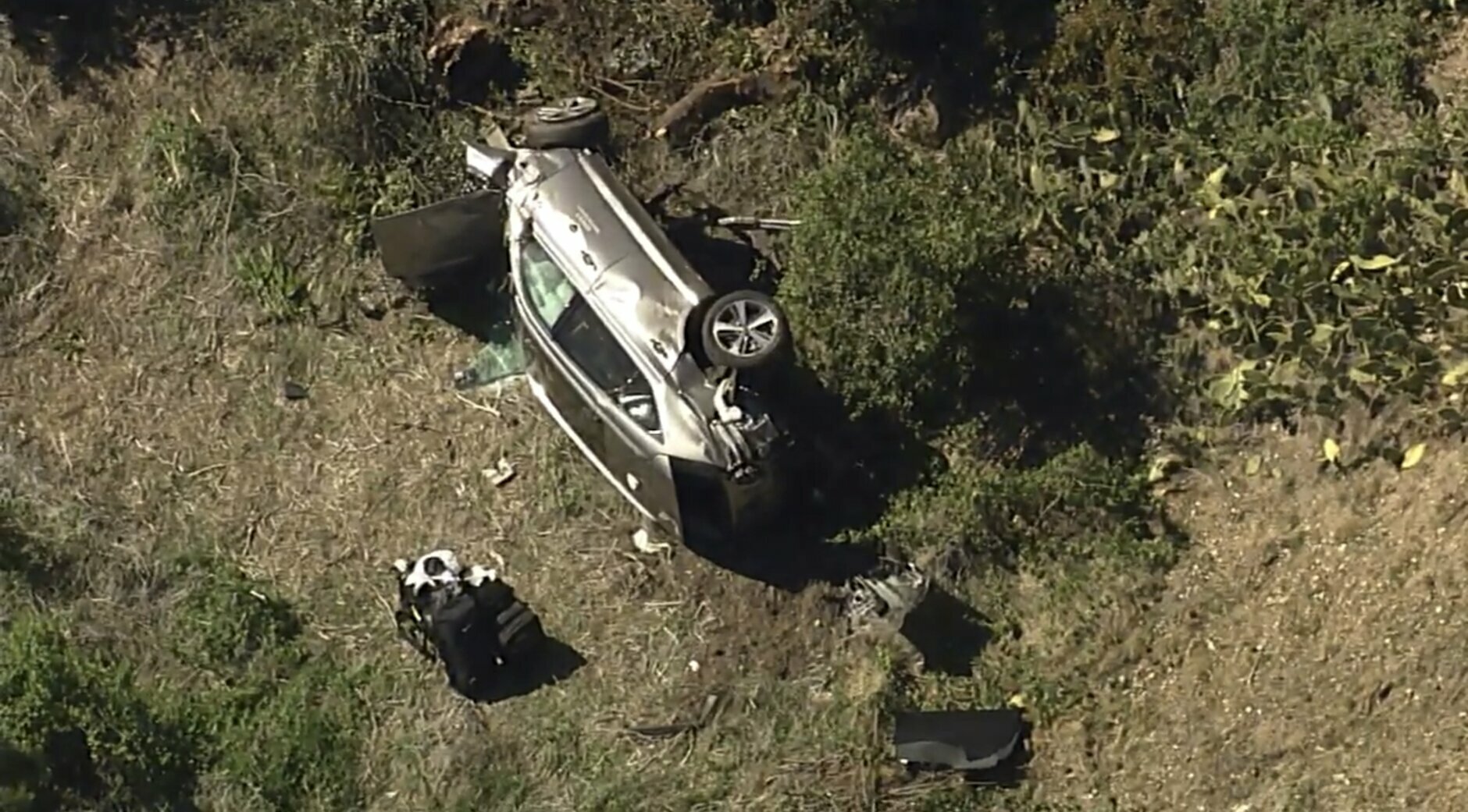 In this aerial image take from video provided by KABC-TV, a vehicle rest on its side after a rollover accident involving golfer Tiger Woods along a road in the Rancho Palos Verdes suburb of Los Angeles on Tuesday, Feb. 23, 2021. Woods had to be extricated from the vehicle with the "jaws of life" tools, the Los Angeles County Sheriff's Department said in a statement. Woods was taken to the hospital with unspecified injuries. The vehicle sustained major damage, the sheriff's department said. (KABC-TV via AP)