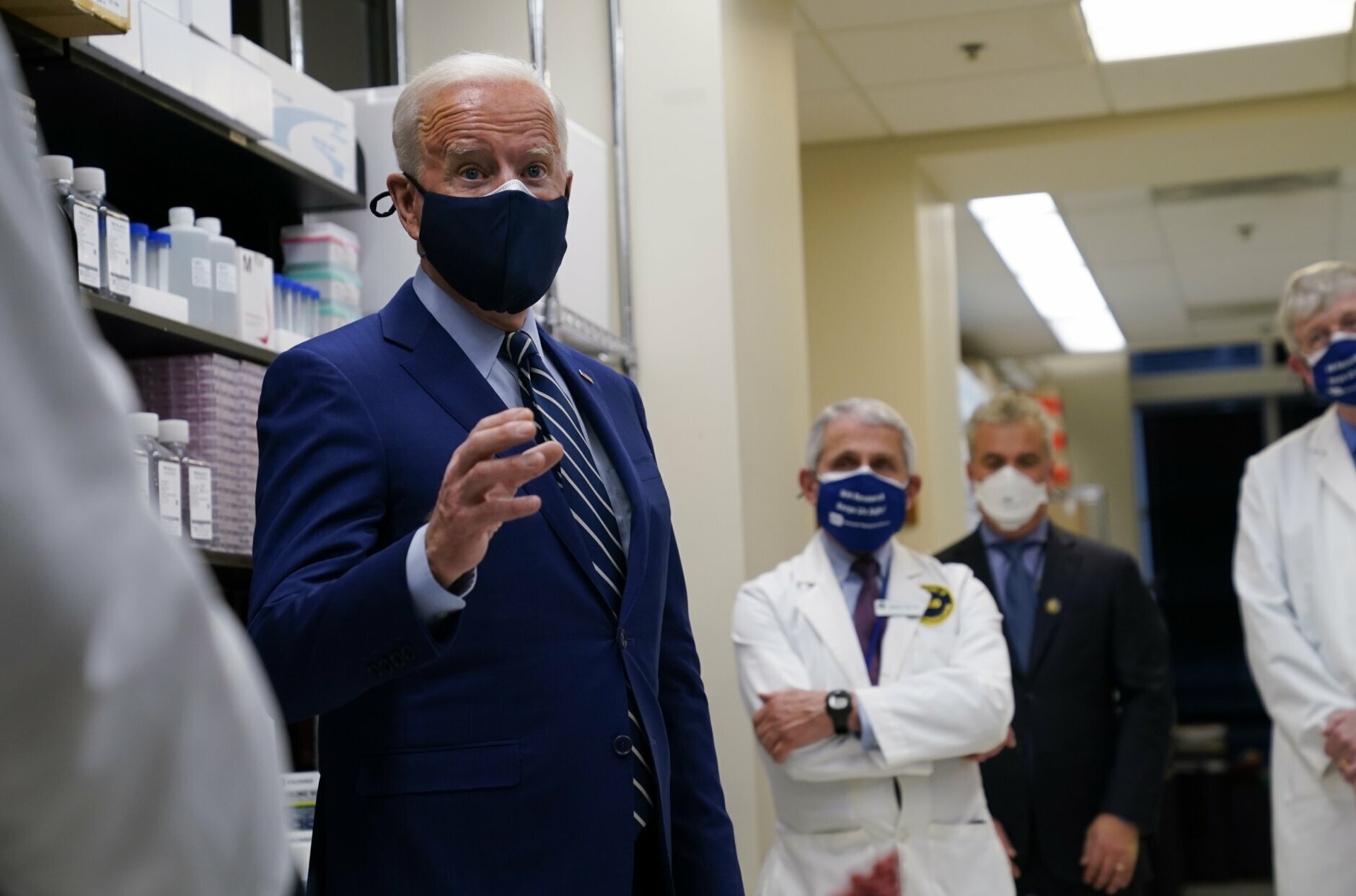 President Joe Biden speaks during a visit at the Viral Pathogenesis Laboratory at the National Institutes of Health (NIH), Thursday, Feb. 11, 2021, in Bethesda, Md. Dr. Anthony Fauci, director of the National Institute of Allergy and Infectious Diseases and NIH Director Francis Collins listen. (AP Photo/Evan Vucci)