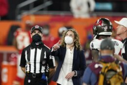 A health care worker tosses the coin before the NFL Super Bowl 55 football game between the Tampa Bay Buccaneers and the Kansas City Chiefs, Sunday, Feb. 7, 2021, in Tampa, Fla. (AP Photo/Ashley Landis)