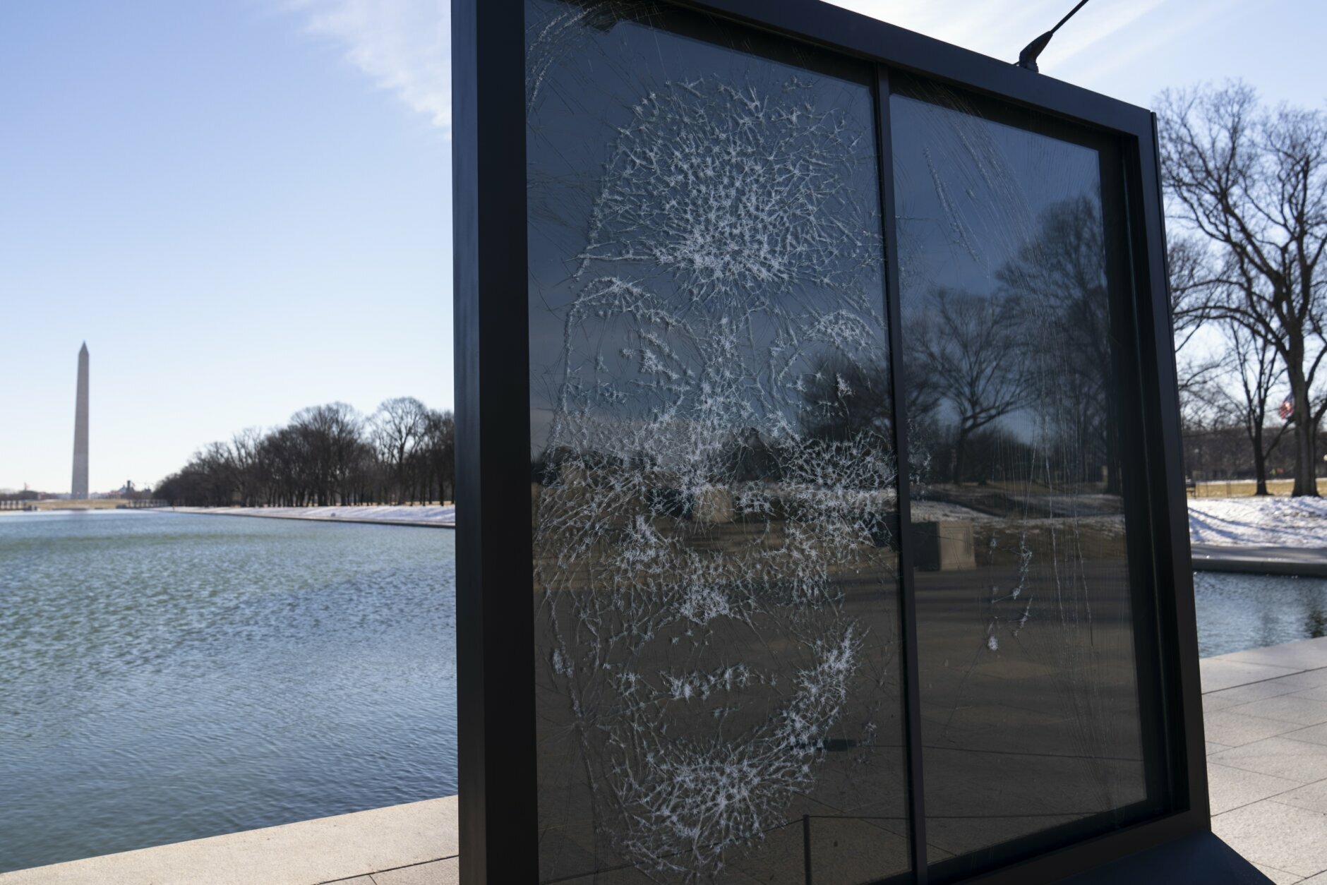 The installation "Vice President Kamala Harris Glass Ceiling Breaker" is seen at the Lincoln Memorial in Washington, Wednesday, Feb. 4, 2021. Vice President Kamala Harris' barrier-breaking career has been memorialized in a portrait depicting her face emerging from the cracks in a massive sheet of glass. Using a photo of Harris that taken by photographer Celeste Sloman, artist Simon Berger lightly hammered on the slab of laminated glass to create the portrait of Harris. The Washington Monument is seen in the distance and the Lincoln Memorial is reflected. (AP Photo/Carolyn Kaster)