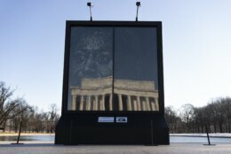The installation "Vice President Kamala Harris Glass Ceiling Breaker" is seen at the Lincoln Memorial, reflected, in Washington, Wednesday, Feb. 4, 2021. Vice President Kamala Harris' barrier-breaking career has been memorialized in a portrait depicting her face emerging from the cracks in a massive sheet of glass. Using a photo of Harris that taken by photographer Celeste Sloman, artist Simon Berger lightly hammered on the slab of laminated glass to create the portrait of Harris. (AP Photo/Carolyn Kaster)