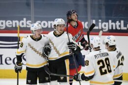 Pittsburgh Penguins left wing Jake Guentzel (59) celebrates his goal with defenseman John Marino (6), defenseman Marcus Pettersson (28) and right wing Kasperi Kapanen (42) during the second period of an NHL hockey game as Washington Capitals left wing Carl Hagelin skates by at back, Tuesday, Feb. 23, 2021, in Washington. (AP Photo/Nick Wass)