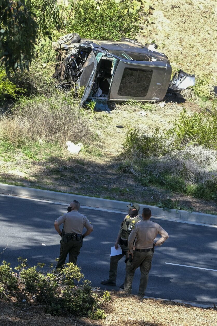 A vehicle rests on its side after a rollover accident involving golfer Tiger Woods along a road in the Rancho Palos Verdes suburb of Los Angeles on Tuesday, Feb. 23, 2021. Woods suffered leg injuries in the one-car accident and was undergoing surgery, authorities and his manager said. (AP Photo/Ringo H.W. Chiu)