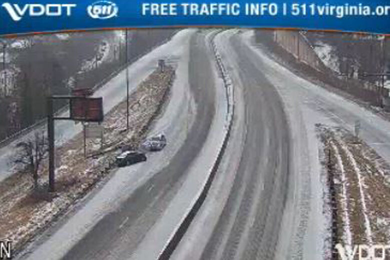 A pair of disabled vehicles on an ice and snow-covered interstate.