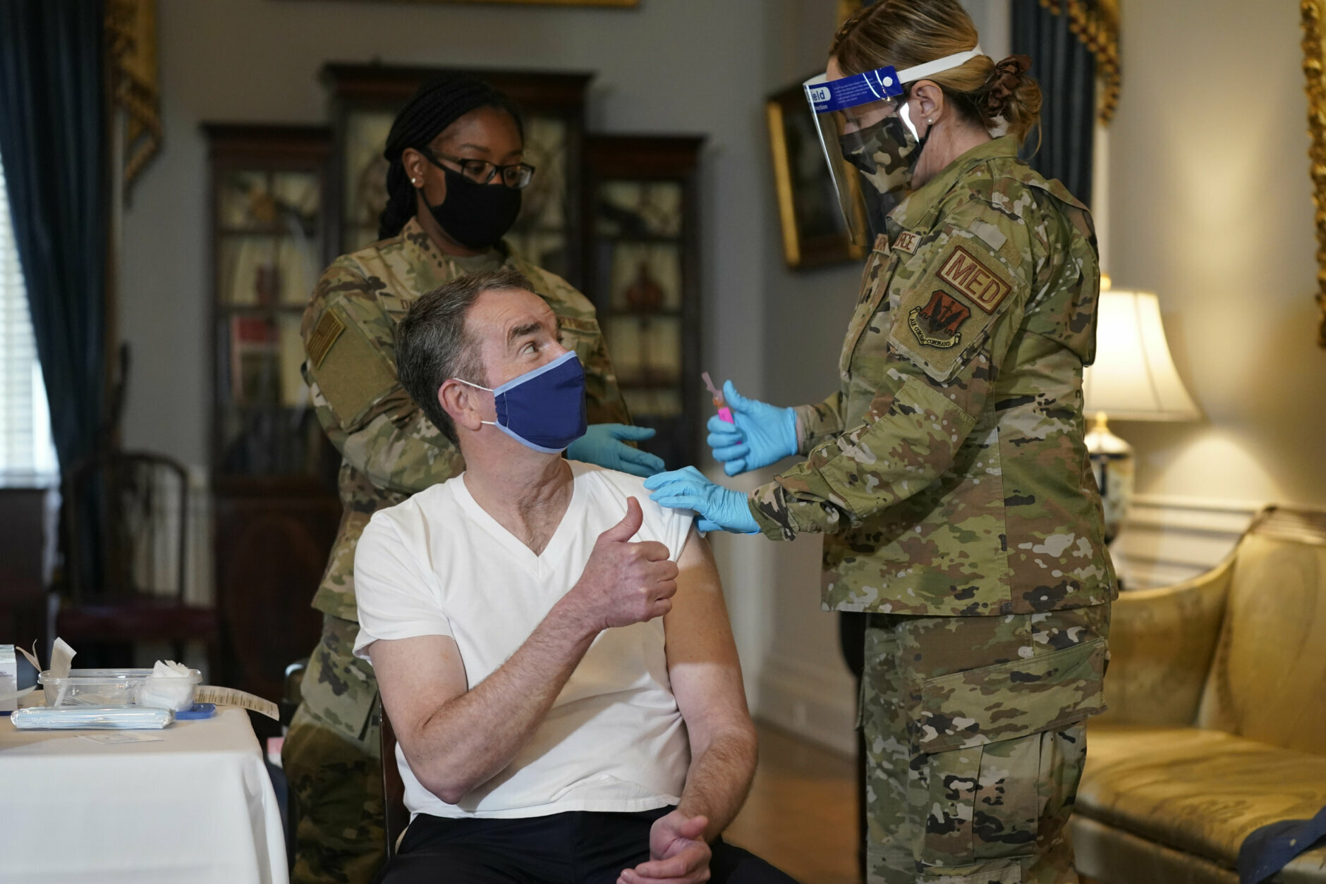 Virginia Gov. Ralph Northam give s a thumbs up after he receives a COVID-19 vaccination from Lt. Col. Kris Clark, of the Virginia Air National Guard at the Governors Mansion in Richmond, Va., Monday, March 15, 2021.  Northam got a shot of the Johnson &amp; Johnson coronavirus vaccine on Monday, joining the growing number of Virginians who are being inoculated against the potentially deadly disease.  (AP Photo/Steve Helber)